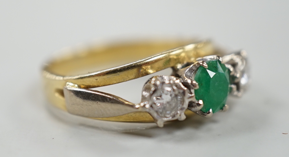 A modern yellow metal, emerald and diamond set three stone ring, size G, gross weight 3.8 grams.